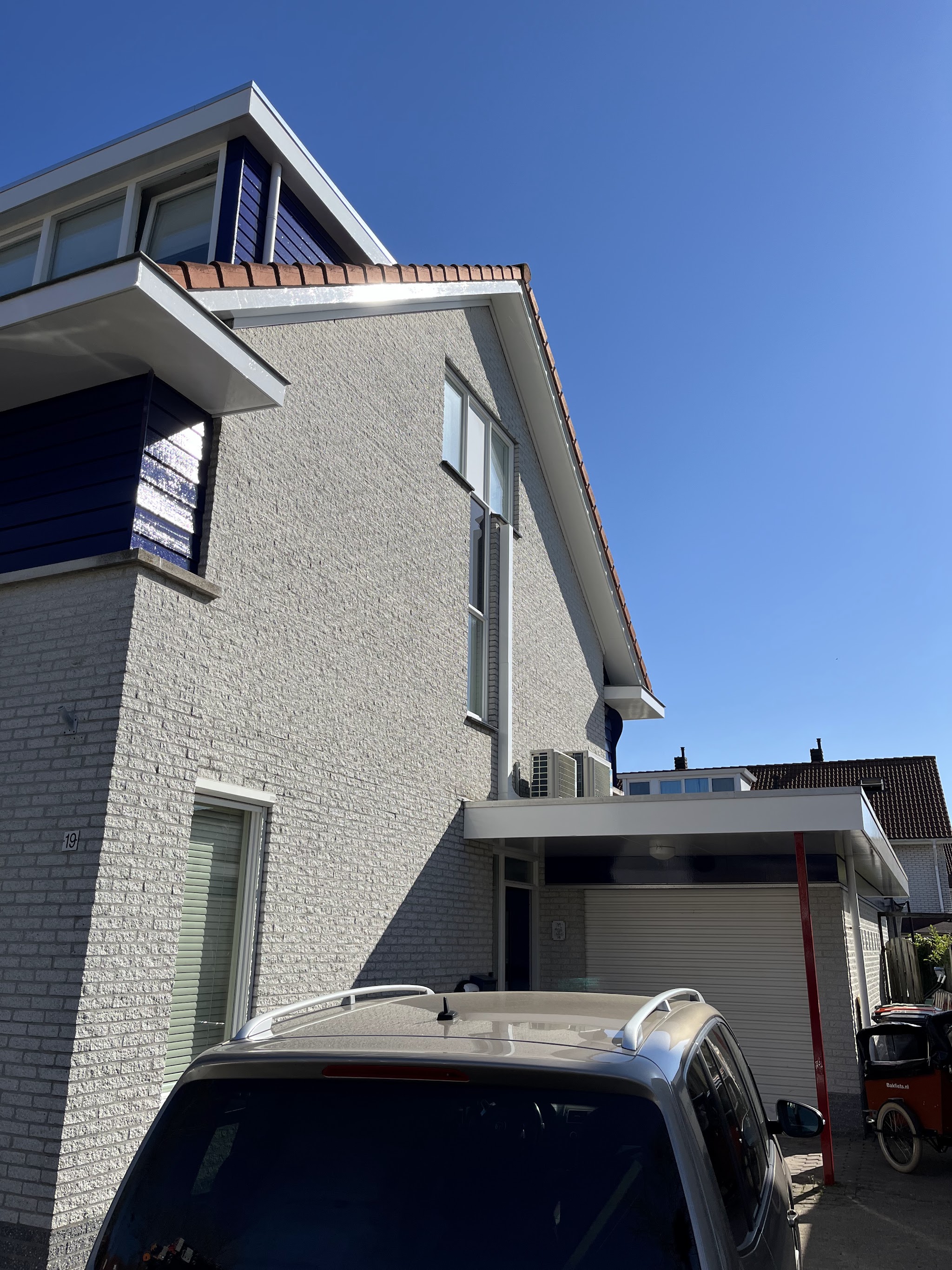 Zijgevel met marineblauw geschilderde boeidelen en witte dakranden