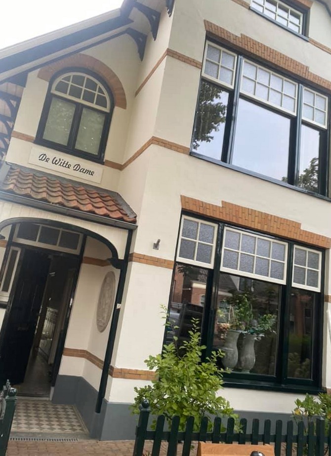 Villa De Witte Dame met crèmekleurige gevel en donkergroen geschilderde kozijnen